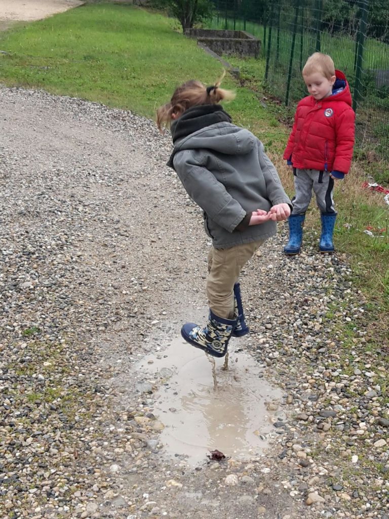 Joie d'un enfant sautant dans une flaque